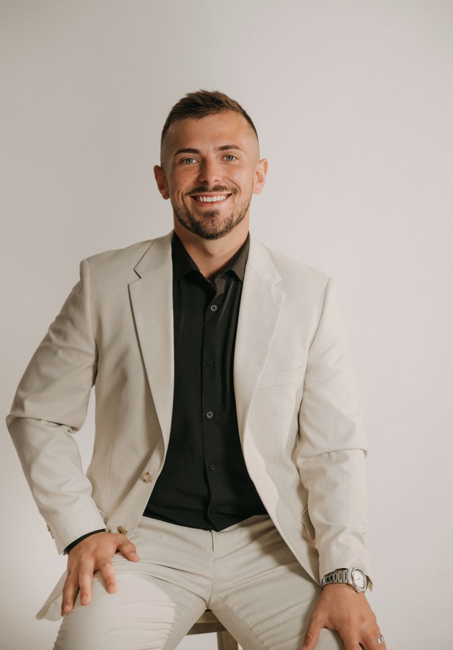 Ross Pino in a light suit, smiling